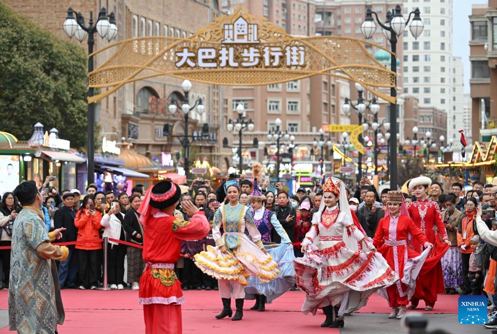 Attendees of the 6th World Media Summit watch performance at the grand bazaar in Urumqi, northwest China's Xinjiang Uygur Autonomous Region, Oct. 16, 2024. The 6th World Media Summit opened on Monday in Urumqi, capital city of Xinjiang. Attendees of the Summit would visit various places of Xinjiang during the Summit period. (Photo:Xinhua)