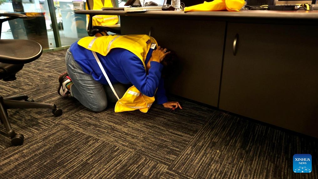 A person practices Drop, Cover and Hold On during an earthquake preparedness drill in Los Angeles County, California, the United States, on Oct. 17, 2024. (Photo: Xinhua)