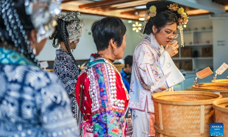 A tourist tastes local snacks at the Qingyan ancient town in Guiyang, capital of southwest China's Guizhou Province, Oct. 16, 2024 (Photo:Xinhua)