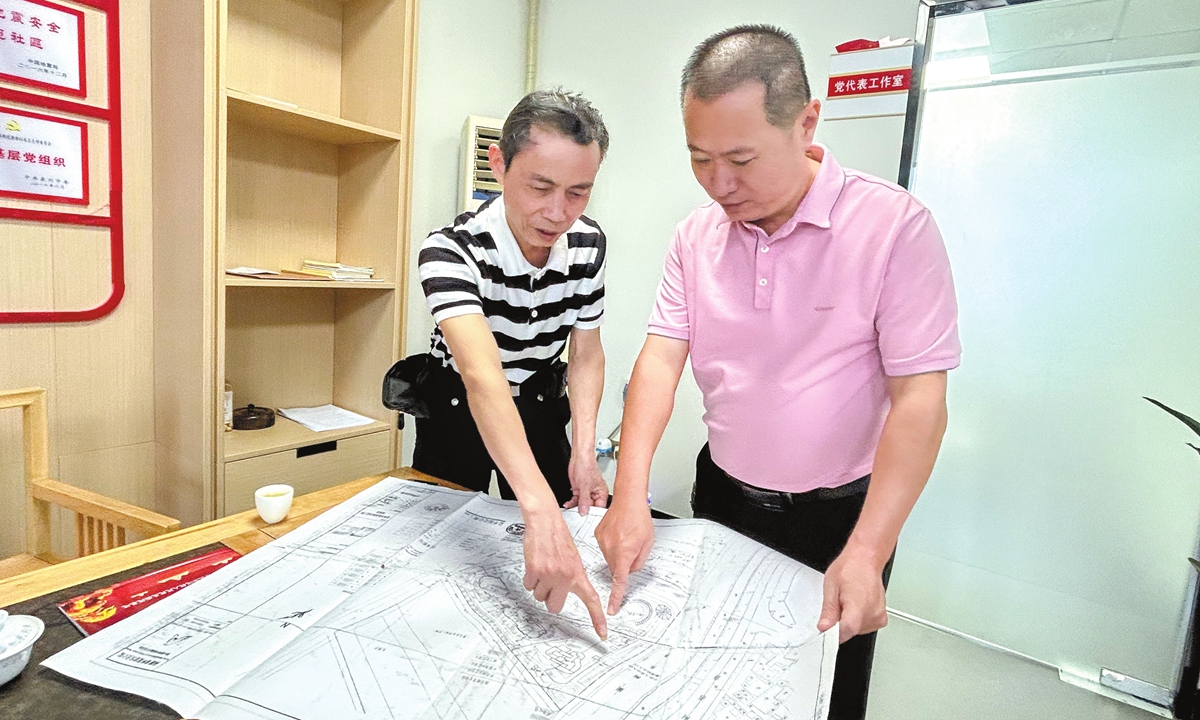 A Quanzhou resident Cai Detuan (left) and local legislator Lin Xinzhou discuss previous boundary issues that once affected Cai's residential compound on October 10, 2024.  Photo: Huang Lanlan/GT 