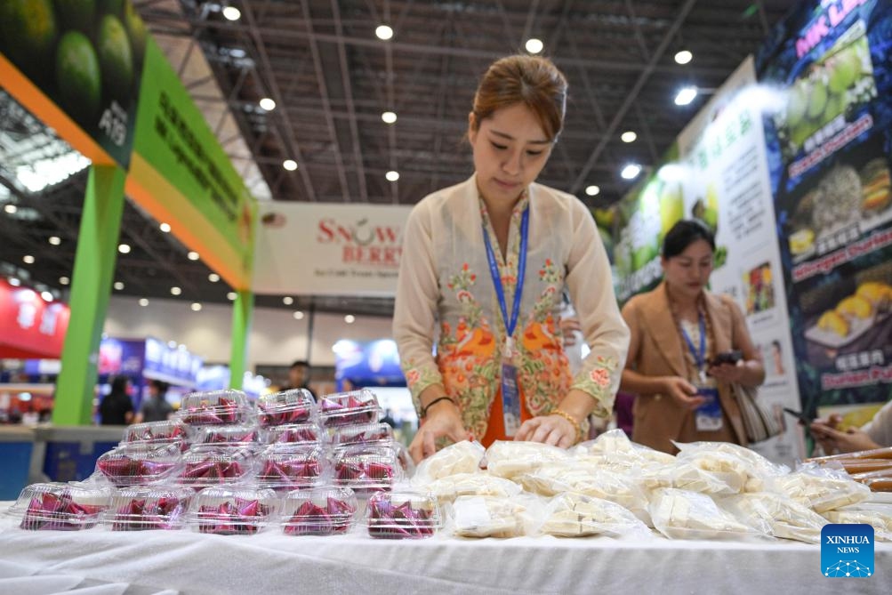 A staff member arranges food from Malaysia during the 2nd Hainan International Tropical Food Supply Chain Expo in Haikou, south China's Hainan Province, Oct. 17, 2024. The 2nd Hainan International Tropical Food Supply Chain Expo kicked off here Thursday. (Photo: Xinhua)