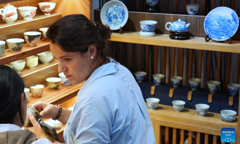 A foreign exhibitor selects ceramic products during the 2024 China Jingdezhen International Ceramic Expo in Jingdezhen, east China's Jiangxi Province, Oct. 18, 2024. The 2024 China Jingdezhen International Ceramic Expo kicked off on Friday in Jingdezhen, renowned worldwide as the porcelain capital, in east China's Jiangxi Province. (Photo: Xinhua)