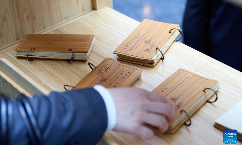 A visitor tries bamboo products on a forum on green industry cooperation in Brussels, Belgium, Oct. 17, 2024. (Photo: Xinhua)