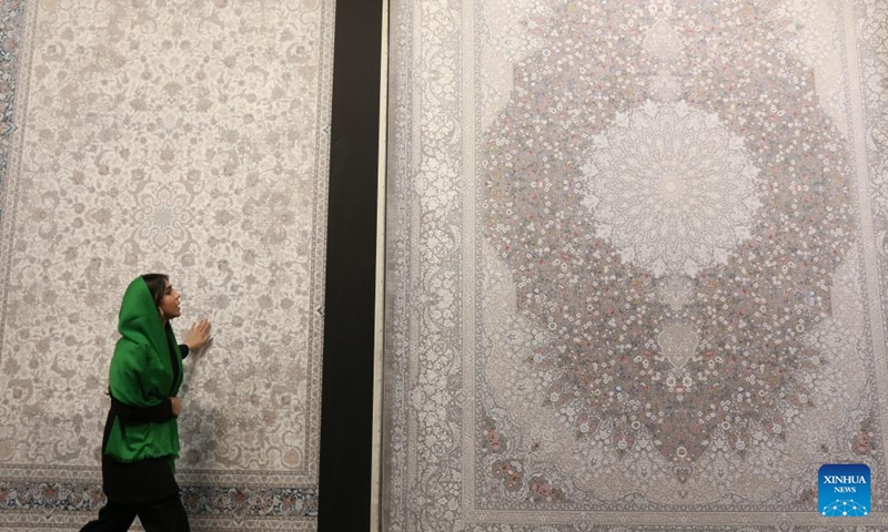 A staff member displays products during the 16th International Floor Coverings, Moquette, Machine-Made Carpet and Related Industries Exhibition in Tehran, Iran, Oct. 17, 2024. The exhibition was held in Tehran from Monday to Thursday. (Photo: Xinhua)