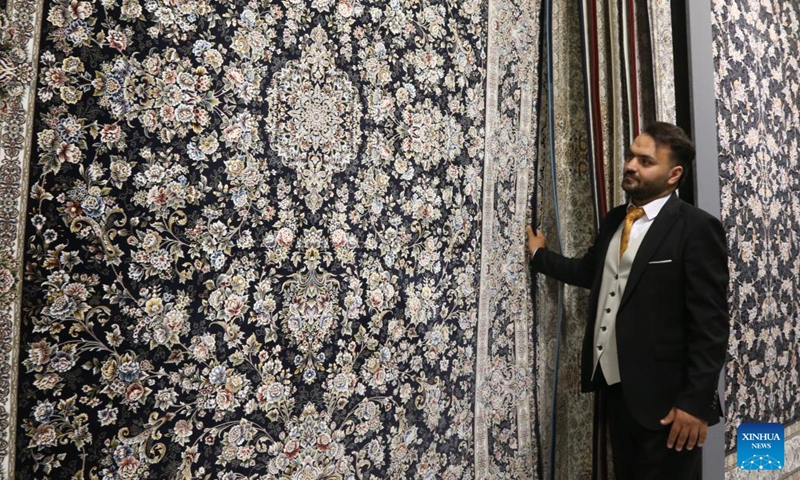 A staff member displays products during the 16th International Floor Coverings, Moquette, Machine-Made Carpet and Related Industries Exhibition in Tehran, Iran, Oct. 17, 2024. The exhibition was held in Tehran from Monday to Thursday. (Photo: Xinhua)