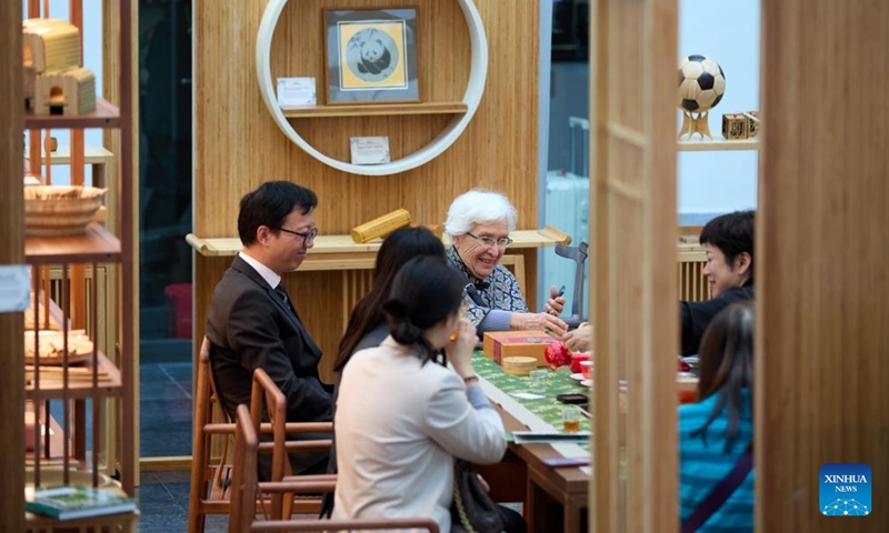 People try bamboo products on a forum on green industry cooperation in Brussels, Belgium, Oct. 17, 2024. (Photo: Xinhua)