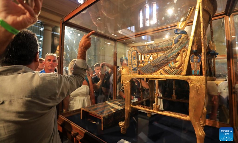 Tourists look at ancient Egyptian King Tutankhamun's gilded wooden throne at Egyptian Museum in Cairo, Egypt, on Oct. 18, 2024. Egypt has entered its peak tourism season as the weather becomes cooler.  (Photo: Xinhua)