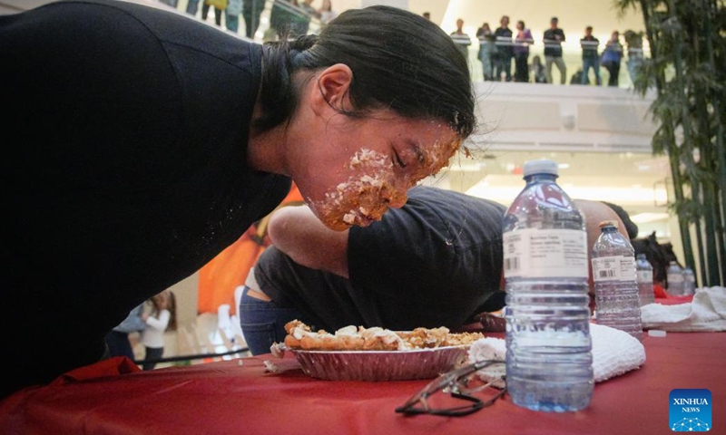 People compete during the pumpkin pie eating contest at Metrotown Shopping Mall in Burnaby, British Columbia, Canada, Oct. 19, 2024.

The competition required participants to finish as much of a 2-pound pie as possible in 5 minutes without using their hands. (Photo: Xinhua)