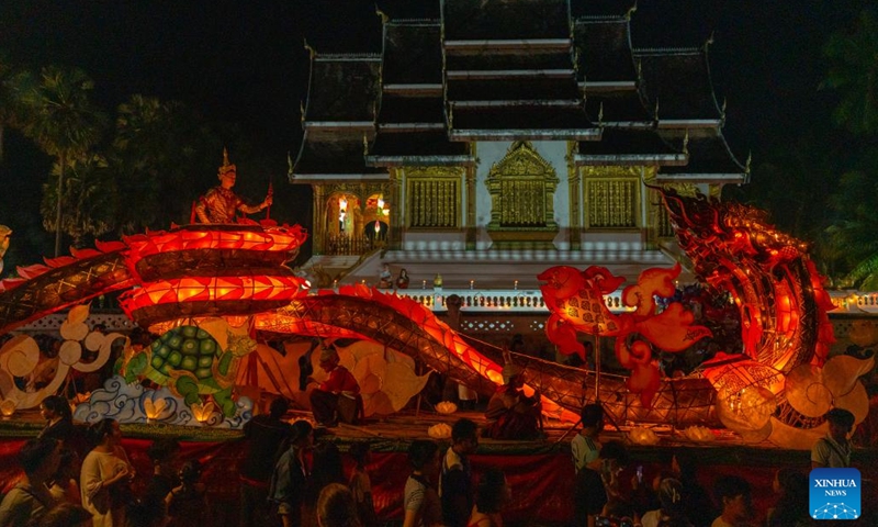 People take part in a parade with a light boat in Luang Prabang, Laos, on Oct. 18, 2024. During the Boun Lai Heua Fai festival, people adorned the city with lanterns, paraded with and later floated large dragon boats and small boats made from banana trees carrying flowers, incense and candles down the Mekong River to let bad luck drift away and good luck flow in.  (Photo: Xinhua)