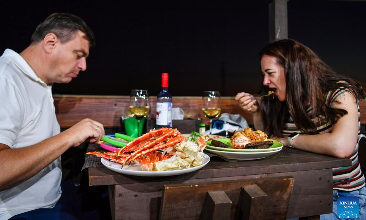 People taste king crabs at a restaurant in Vladivostok, Russia, Sept. 2, 2024. Hunchun City of northeast China's Jilin Province has a nickname capital of king crabs among netizens. Every day, trucks fully loaded with fresh seafood imports enter the city via a land checkpoint bordering Russia. The Russian king crab, also known as the Kamchatka crab, is the star product. (Photo: Xinhua)