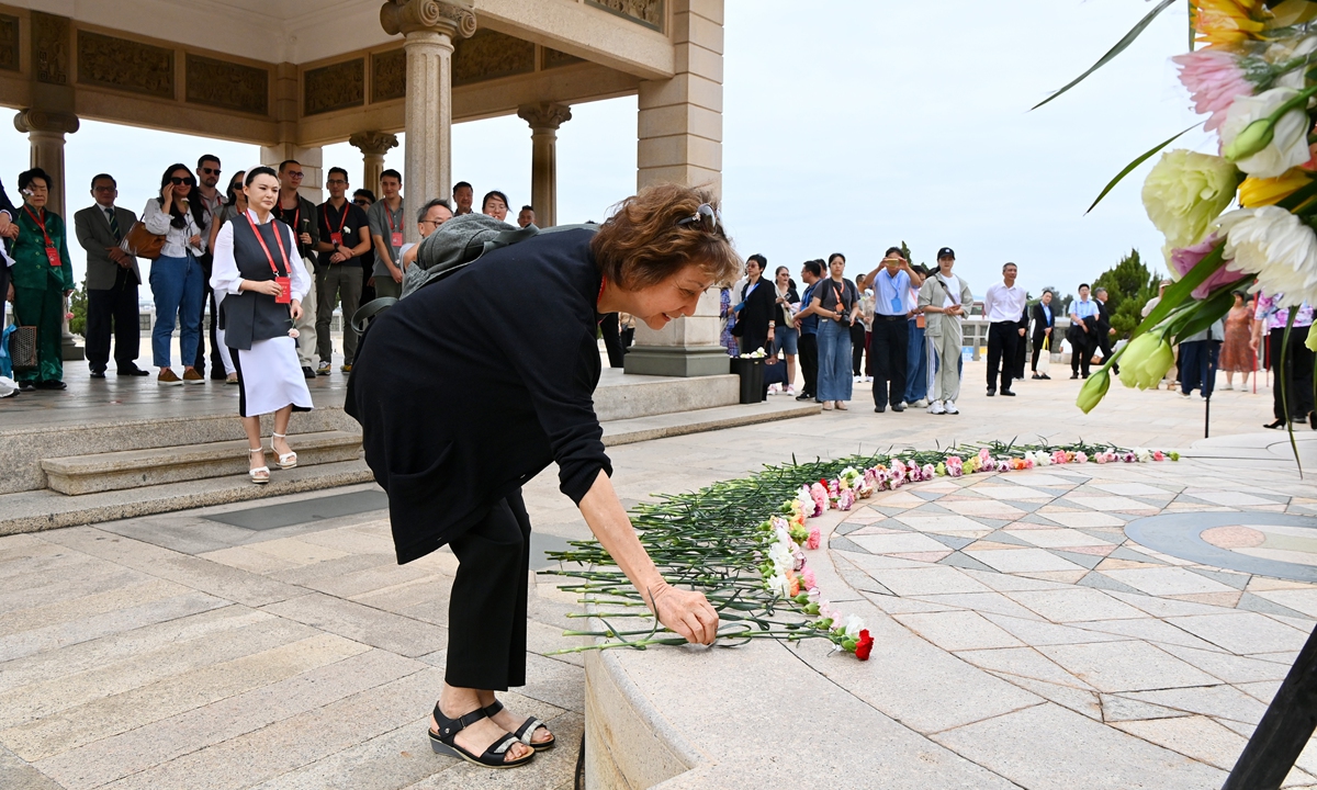 Peggy Tan Poey Gee, the granddaughter of Tan Kah Kee, places a flower to pay tribute to the renowned patriot in Xiamen, East China's Fujian Province, on the occasion of Tan's 150th birthday, along with Tan's family representatives and people from all walks of life. Tan was an overseas Chinese businessman and philanthropist who established a number of schools, including Xiamen University in 1921. Photo: VCG