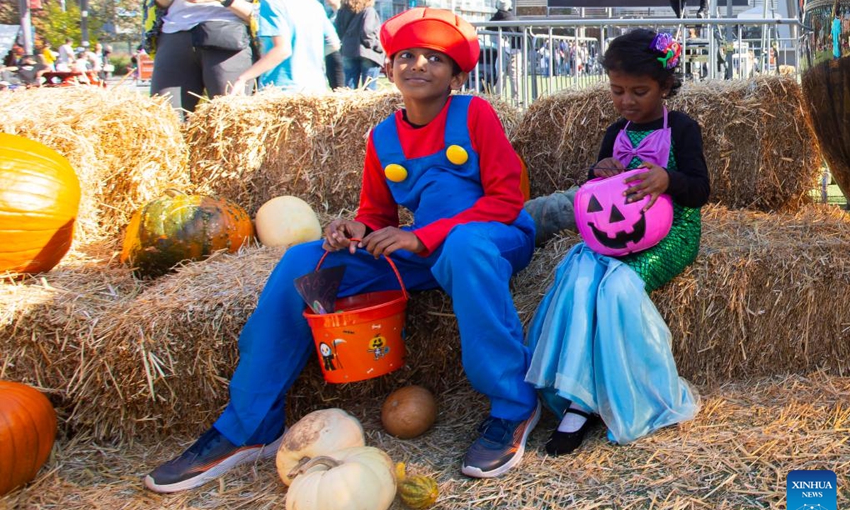 Dressed-up children pose for photos during Celebration Scare, a family-friendly Halloween bash held in Mississauga, Ontario, Canada, on Oct. 19, 2024.  (Photo: Xinhua)