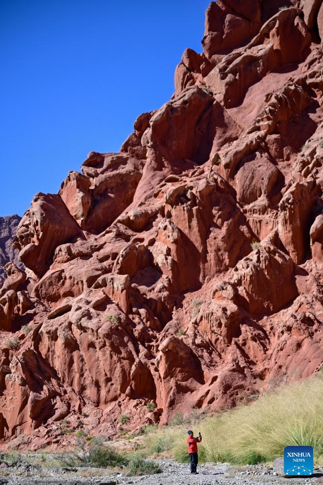 Wu Xinhua, a member of a scientific expedition team, takes pictures of rock formations at a canyon in Bulungkol Township of Akto County, Kirgiz Autonomous Prefecture of Kizilsu in northwest China's Xinjiang Uygur Autonomous Region, Oct. 19, 2024. A multidisciplinary scientific expedition was launched on Saturday in Atux City in Xinjiang. (Photo: Xinhua)