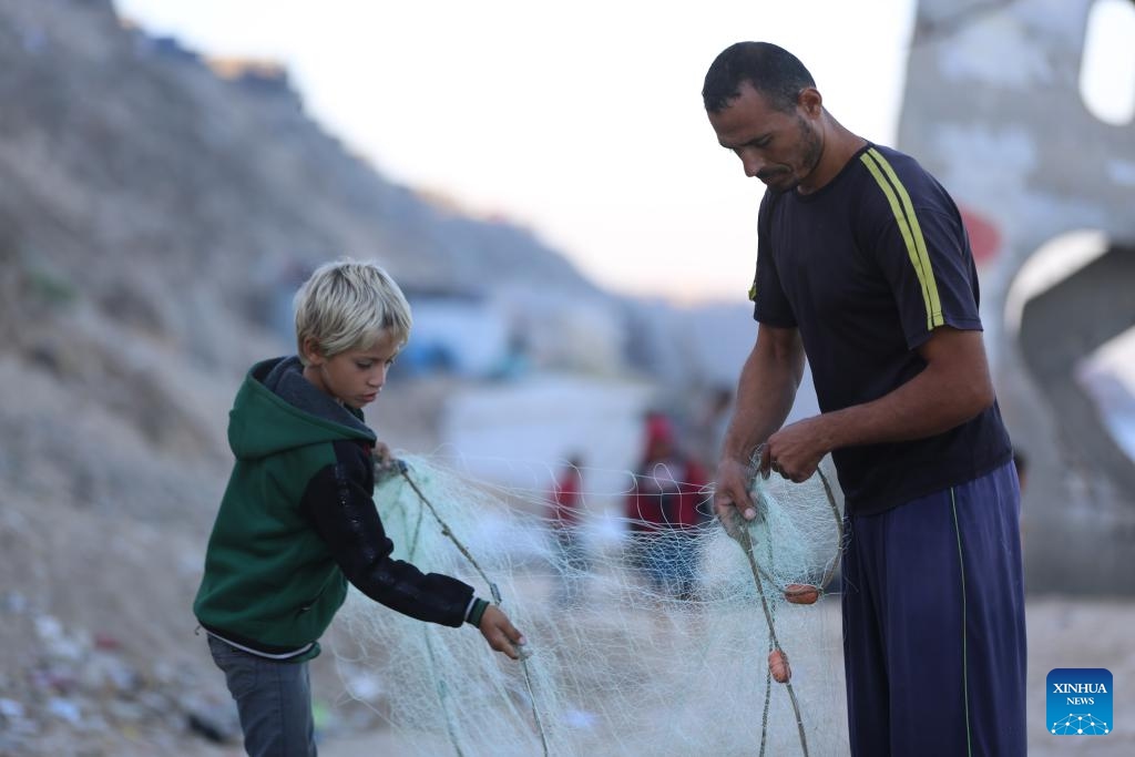 Palestinian fishermen work on the seashore in the city of Deir al-Balah, in the central Gaza Strip, on Oct. 20, 2024. (Photo: Xinhua)