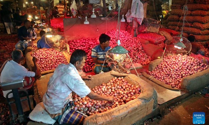 Vendors sell onions at a fruit and vegetable market in Dhaka, Bangladesh, Oct. 19, 2024. (Photo: Xinhua)