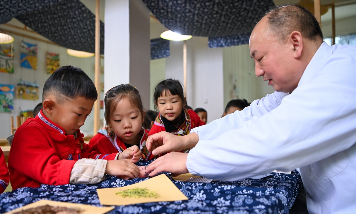 Children from a local kindergarten learn about traditional Chinese medicine (TCM) from a TCM practitioner in Youyang county, Southwest China's Chongqing Municipality, to mark the World Traditional Medicine Day which falls on October 22, 2024. Schools from across the country organized activities centered around TCM to help students experience the charm of this cultural heritage. Photo: VCG