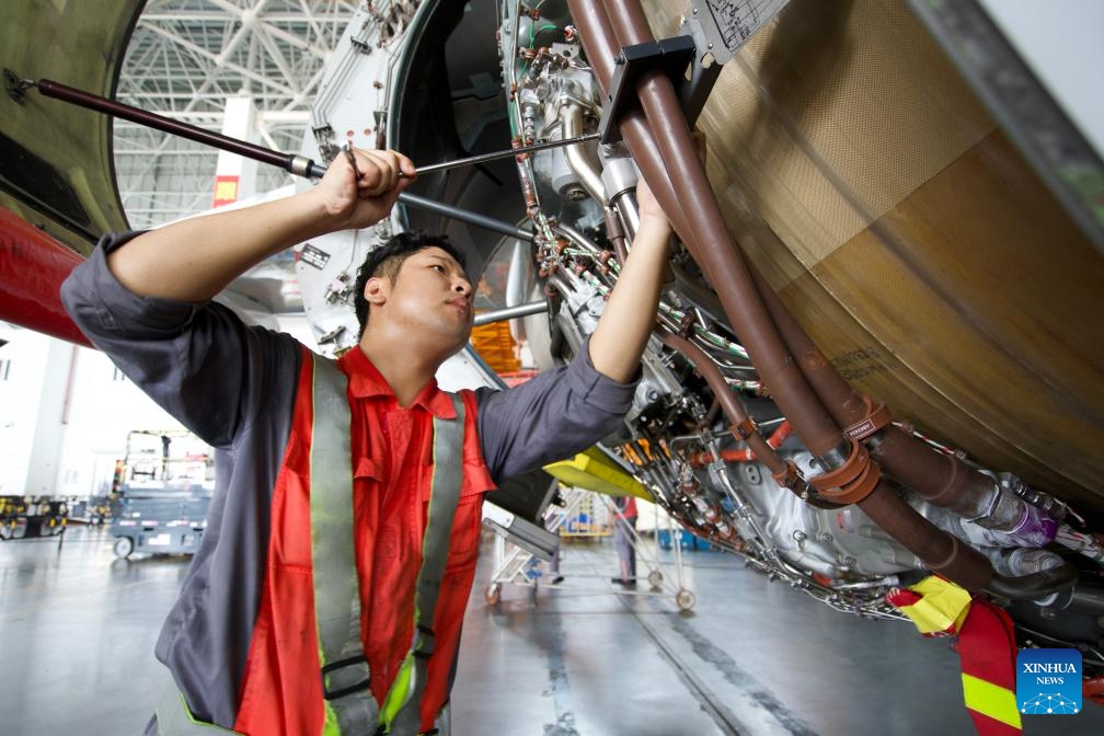 A worker of HNA Technic changes an engine part for an inbound airplane at the one-stop aircraft maintenance base of Hainan Free Trade Port in Haikou, south China's Hainan Province, Oct. 21, 2024. Inbound airplanes in Hainan are eligible for preferential treatments of the free trade port including exemption of cash deposite as well as duty-free fuel and maintenance supplies. (Photo: Xinhua)