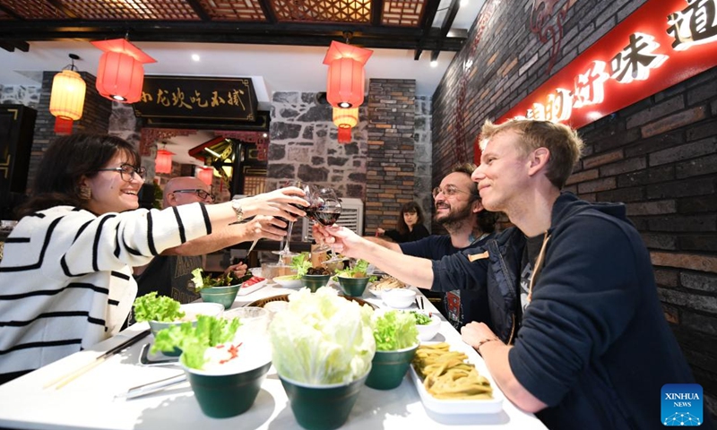 People enjoy wine at a Chinese restaurant in Geneva, Switzerland, Oct. 21, 2024. As October ushers in the arrival of autumn, Switzerland enters its grape harvest season. Wineries here will then convert freshly harvested grapes into inviting wine products through processes that combine both traditional and modern technologies. (Photo: Xinhua)