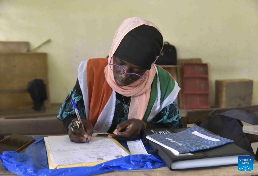 A staff member registers information for voters at a voter registration center in Abidjan, Cote d'Ivoire, on Oct. 22, 2024. The revision of the electoral list in Cote d'Ivoire started on Oct. 19 in preparation for next year's presidential election. The Independent Electoral Commission (CEI) forecasts that about 4.5 million new applicants will register by the end of the revision operation, which runs from Oct. 19 through Nov. 10. (Photo: Xinhua)