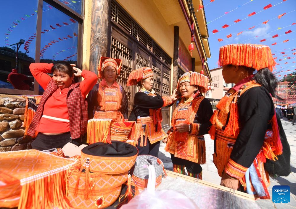 Senior people of Yao ethnic group select costumes at a folk fair in Changping Yao Township in Mengshan County, Wuzhou City, south China's Guangxi Zhuang Autonomous Region, Oct. 23, 2024. Various cultural activities have boosted the unity and common development of all ethnic groups in Mengshan. (Photo: Xinhua)