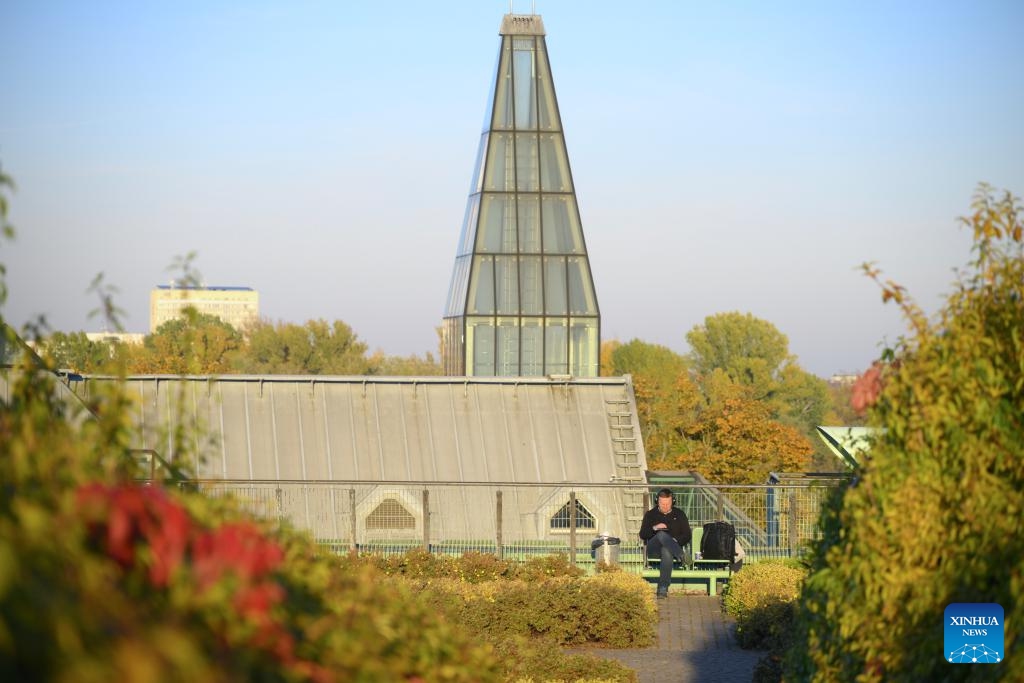 A man enjoys the warm autumn weather in the rooftop garden of the Warsaw University Library in Warsaw, Poland, on Oct. 22, 2024. The rooftop garden of the Warsaw University Library is one of the largest roof gardens in Europe and a popular spot to see city views. (Photo: Xinhua)