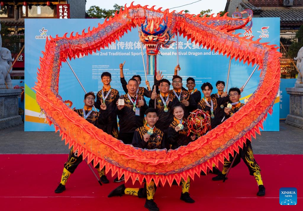 Members of Malaysia Johor Loong & Lion Dance Sport Association pose for photos after the awarding ceremony of the festival in Kunming, capital of southwest China's Yunnan Province, on Oct. 18, 2024. The 2nd Traditional Sports International Festival was held in Kunming, capital of southwest China's Yunnan Province from Oct. 17 to Oct. 21, 2024. The festival includes Wushu, Health Qigong, Go (Weiqi) and Dragon and Lion Dance, attracting contestants from 27 countries and regions. (Photo: Xinhua)