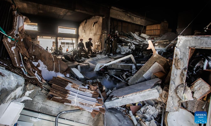 Israeli security forces work at a factory damaged in a rocket attack from Lebanon, at Na'aman industrial park in Acre, northern Israel, on Oct. 23, 2024. A barrage of 25 projectiles was fired from Lebanon into the Western Galilee region, most of which were intercepted by the Israeli air defense, according to the Israel Defense Forces (IDF). (Photo: Xinhua)