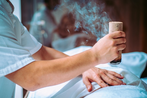 A TCM practitioner performs moxibustion therapy. Photo: VCG 