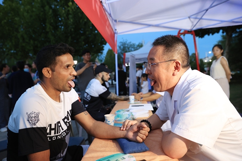 A foreign visitor (left) experiences pulse diagnosis at a night market in Dongying, East China's Shandong Province, on August 16, 2024. Photo: VCG 