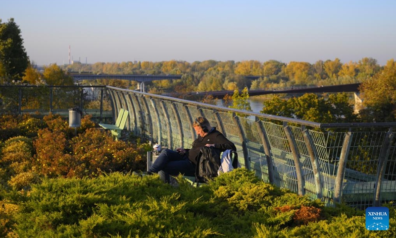 A man enjoys the warm autumn weather in the rooftop garden of the Warsaw University Library in Warsaw, Poland, on Oct. 22, 2024. The rooftop garden of the Warsaw University Library is one of the largest roof gardens in Europe and a popular spot to see city views. (Photo: Xinhua)