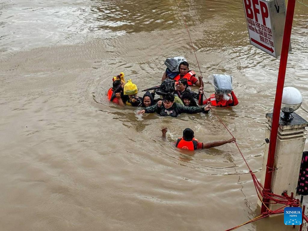 Rescuers evacuate residents from the floods caused by Tropical Storm Trami in Camarines Sur Province, the Philippines on Oct. 24, 2024. At least 22 people have been killed and nine others are missing due to massive flooding and landslides triggered by Tropical Storm Trami, which continues to rip through the Philippines on Thursday, authorities said. (Photo: Xinhua)