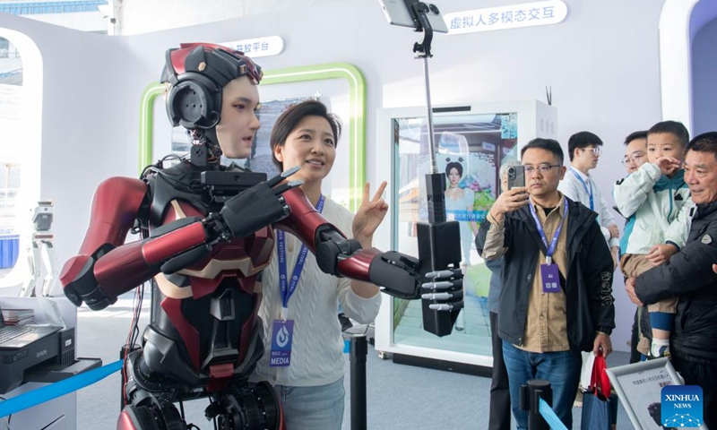 A humanoid robot takes selfies with a visitor at the 7th World Voice Expo in Hefei, east China's Anhui Province, Oct. 24, 2024. The 7th World Voice Expo and the iFlytek 1024 Global Developer Festival kicked off here on Thursday. The latest achievements and application of AI technology will be on display at the four-day event. (Photo: Xinhua)