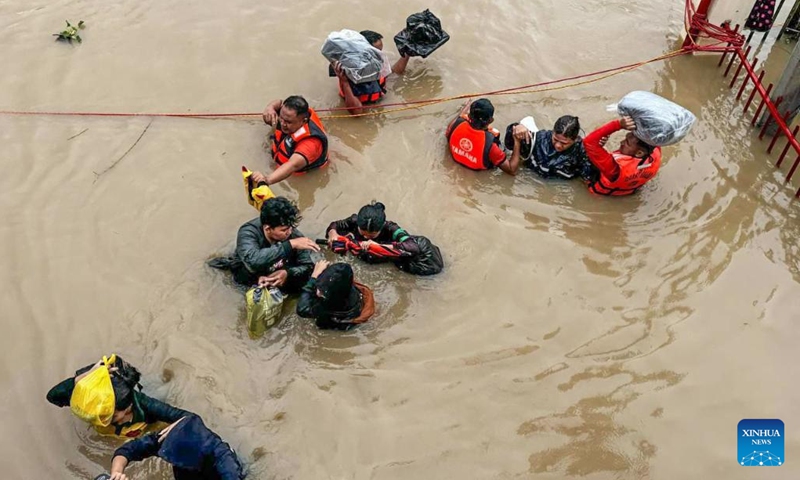 Rescuers evacuate residents from the floods caused by Tropical Storm Trami in Camarines Sur Province, the Philippines on Oct. 24, 2024. At least 22 people have been killed and nine others are missing due to massive flooding and landslides triggered by Tropical Storm Trami, which continues to rip through the Philippines on Thursday, authorities said. (Photo: Xinhua)