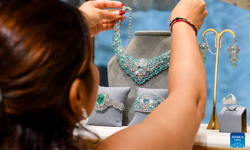 A woman arranges jewelry at a stall during the ASJAD Jewelry Exhibition at Alhazm Mall in Doha, Qatar, Oct. 24, 2024. The exhibition is held here from Oct. 24 to 29. (Photo: Xinhua)