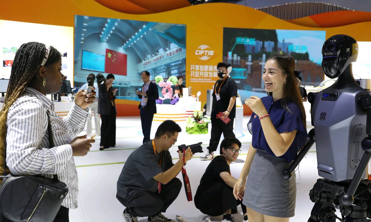 A Bulgarian student takes a photo with a robot at the China International Fair for Trade in Services, on September 12, 2024, in Beijing. Photo: VCG