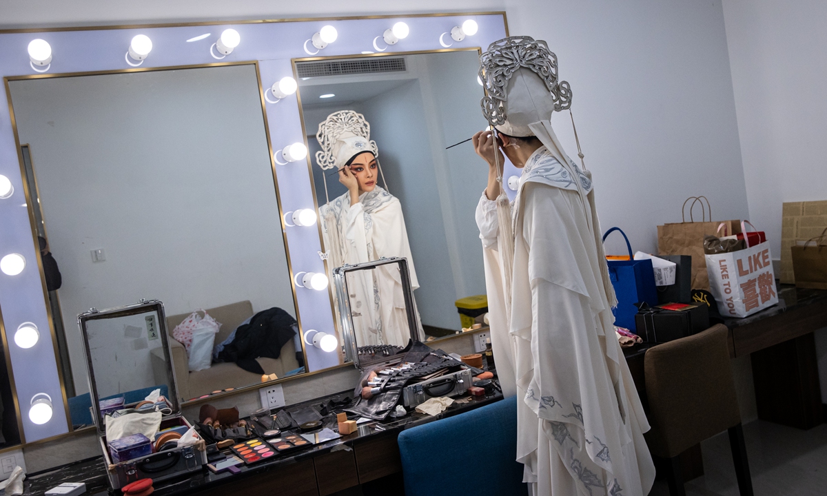 Yueju Opera actress Chen Lijun applies makeup backstage.   Photo: VCG