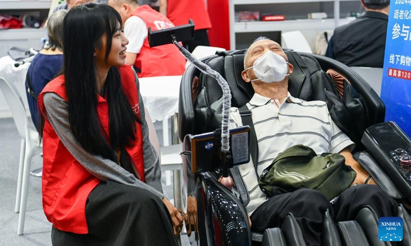 A senior man tries out a massage armchair at the 2024 Shenzhen International Intelligent Elderly Care Industry Expo in Shenzhen, south China's Guangdong Province, Oct. 27, 2024. A total of 203 exhibitors from home and abroad have brought more than 1,000 products and technologies for elderly care to the expo, which was held from Oct. 25 to 27 in Shenzhen. (Photo: Xinhua)