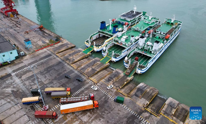 This aerial drone photo taken on Oct. 27, 2024 shows trucks driving onto a ro-ro ship at Xiuying Port in Haikou, south China's Hainan Province. The Xinhai Port, Xiuying Port and a railway port in Haikou resumed operation on Sunday afternoon as the impact of Typhoon Trami, this year's 20th typhoon, weakened. (Photo: Xinhua)