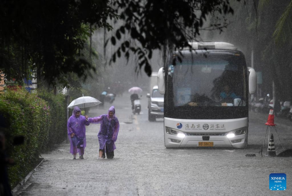 People and vehicles move through a waterlogged road in Sanya, south China's Hainan Province, Oct. 28, 2024. Some parts of Hainan Province experienced heavy rainfall due to the influence of Typhoon Trami. (Photo: Xinhua)