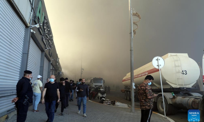 People pass by the fire scene at a warehouse in Baghdad, Iraq on Oct. 27, 2024. A fire broke out at a warehouse in Iraqi capital Baghdad on Sunday. (Photo: Xinhua)