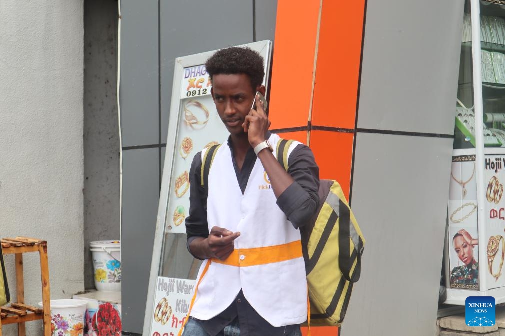 Amanuel Demissie, a backpack biker of Pick Delivery, calls a customer in Adama, the capital of Ethiopia's Oromia regional state, on Oct. 11, 2024. (Photo: Xinhua)