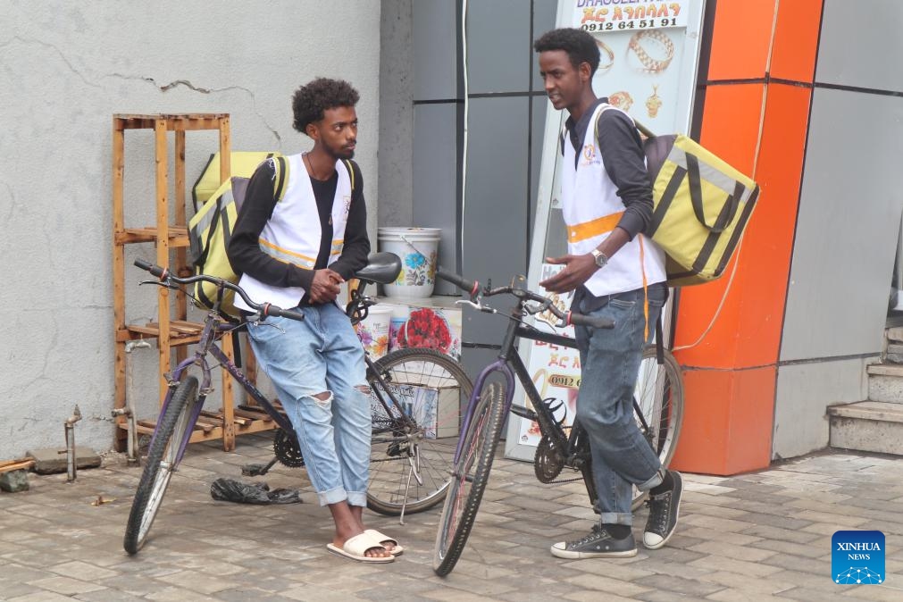 Amanuel Demissie (R), a backpack biker of Pick Delivery, chats with his coworker in Adama, the capital of Ethiopia's Oromia regional state, on Oct. 11, 2024. (Photo: Xinhua)