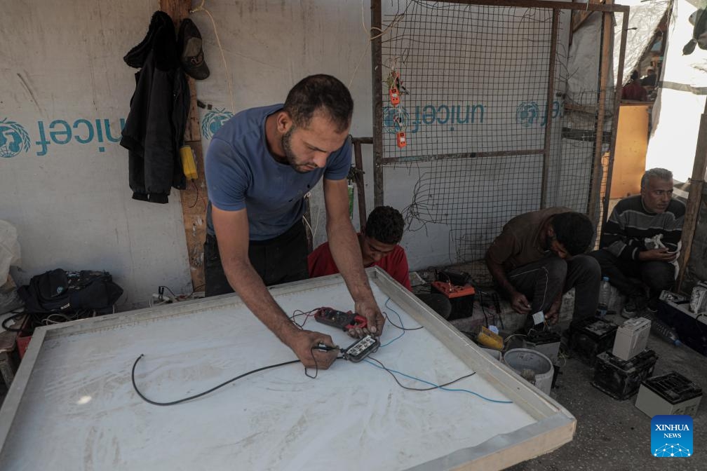 A Palestinian engineer works to repair solar panels in the Mawasi area of Khan Younis in the southern Gaza Strip, on Oct. 27, 2024. Displaced people here are amid ongoing energy crisis and power outages, which have lasted for more than a year due to the Israeli aggression on the Gaza Strip. (Photo: Xinhua)