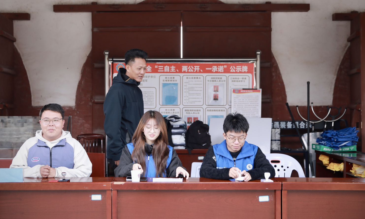 Curator Yin Zhenxing (second left) and Shanxi Institute of Science and Technology students discuss volunteer duties at the Yuhuang Temple, on October 19, 2024. Photo: Lin Xiaoyi/GT 