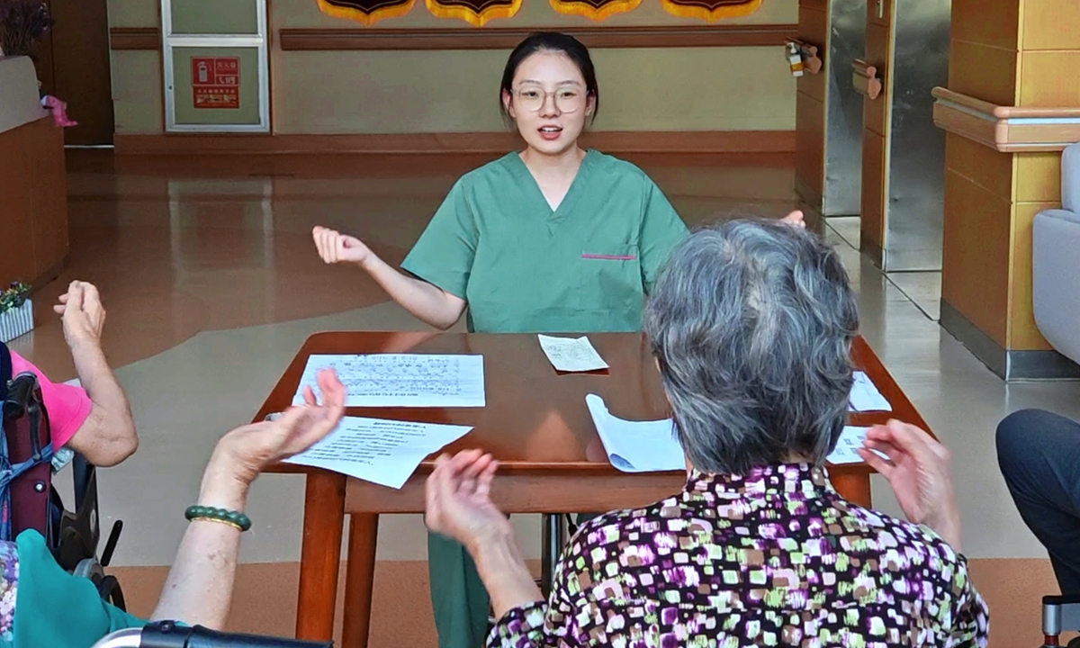 Jiang Hao teaches some senior citizens to sing a song at an eldercare home she works for in East China's Shandong Province. Photo: Courtesy of Jiang