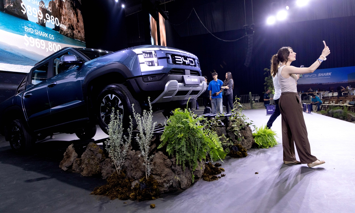 Attendees take photos with the BYD Co. Shark plug-in hybrid electric vehicle (PHEV) pickup truck during the launch event at Expo Santa Fe Mexico in Mexico City, Mexico, on Tuesday, May 14, 2024. Photo: VCG