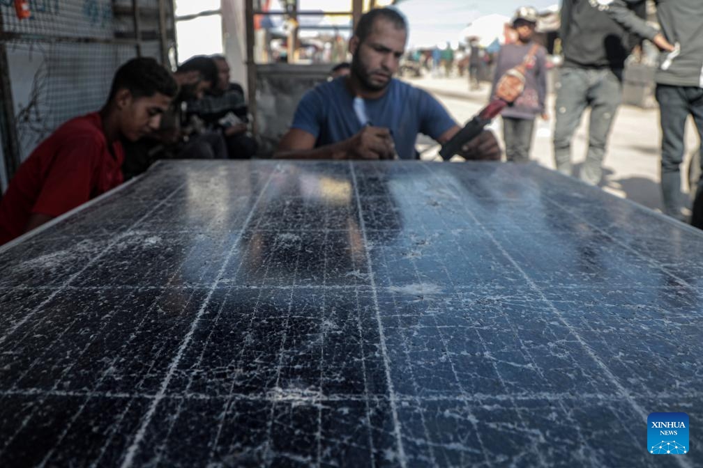 A Palestinian engineer works to repair solar panels in the Mawasi area of Khan Younis in the southern Gaza Strip, on Oct. 27, 2024. Displaced people here are amid ongoing energy crisis and power outages, which have lasted for more than a year due to the Israeli aggression on the Gaza Strip. (Photo: Xinhua)