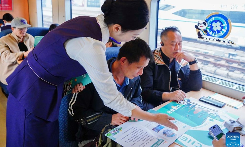 A train attendant introduces to passengers the seventh China International Import Expo (CIIE) during a promotion event for the CIIE on the train D3205 on Oct. 28, 2024. The CIIE is scheduled to take place in Shanghai from Nov. 5 to 10. (Photo: Xinhua)