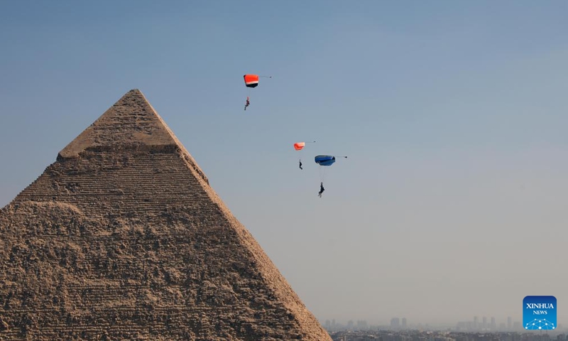 Skydivers fly by a pyramid during the skydiving festival Jump Like a Pharaoh at Giza Pyramids scenic spot in Giza, Egypt, on Oct. 29, 2024. The seventh edition of the skydiving festival kicked off at the Giza Pyramids on Tuesday, attracting around 200 skydivers. (Photo: Xinhua)