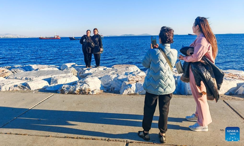 This photo taken with a mobile phone shows people taking pictures on the coast of Marmara Sea in Istanbul, Türkiye, Oct. 26, 2024. (Photo: Xinhua)